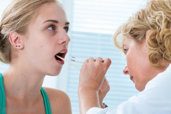 Բժիշկը ուսումնասիրում է բերանի խոռոչը պապիլոմաների առկայության համար
